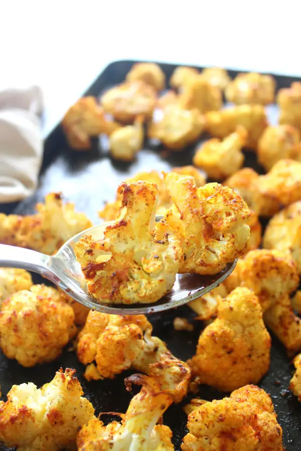 25 minute vegan Golden Spice Roasted Cauliflower is unbelievably delicious! Crispy on the edges, flavourful, and packed with vitamins, minerals, antioxidants and anti-inflammatories. Such an easy side dish! | berrysweetlife.com