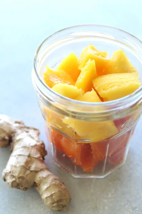 A vegan, easy to make Nourishing Mango Papaya Ginger Smoothie made with just 4 ingredients and your blender in 5 minutes! It tastes wonderful, is silky smooth, overflowing with healthy goodness | berrysweetlife.com