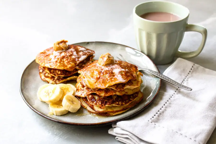 Flourless banana pancake stack topped with nut butter and coconut milk